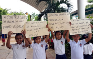 Alumnos de la escuela primaria Cuauhtémoc en la comunidad San José Ixtapa, municipio de Zihuatanejo, recibieron con pancartas en las que piden salones nuevos al director técnico del Instituto Guerrerense para la Infraestructura Física Educativa (IGIFE), Roosmel Navarrete Ureña, quien acudió al plantel a evaluar el daño del inmueble. Foto: Brenda Escobar