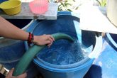 Un vecino del barrio de San Antonio quien no cuenta con el servicio de agua potable desde hace mas de un mes, llena sus tinas y tambos de una pipa de agua potable, la cual comprarán en 300 pesos por 4 mil litros. Foto: Jesús Eduardo Guerrero