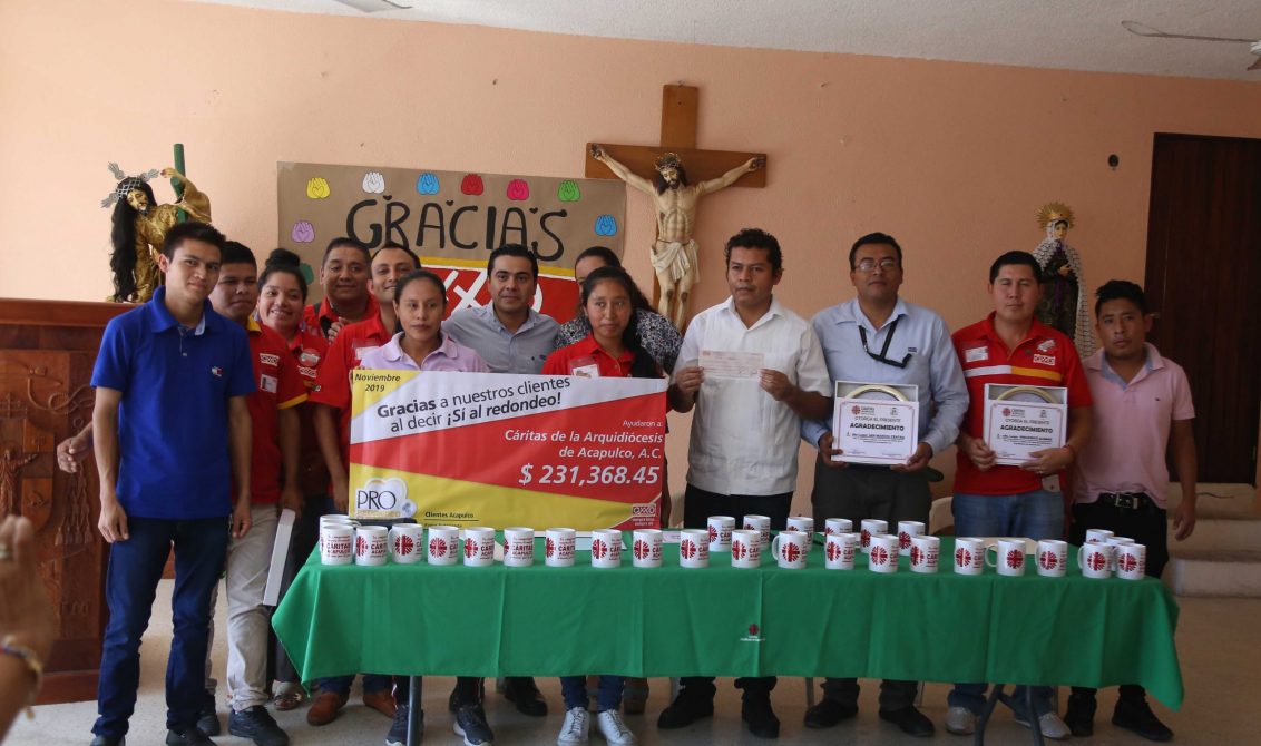 La representante la cadena de tiendas OXXO, Berenice Mendoza en la entrega de un donativo a la Asociación Civil Caritas de la Arquidiócesis de Acapulco, con la representación del padre Leonardo Morales, en la Casa de la Arquidiócesis de Acapulco. Foto: Jesús Trigo