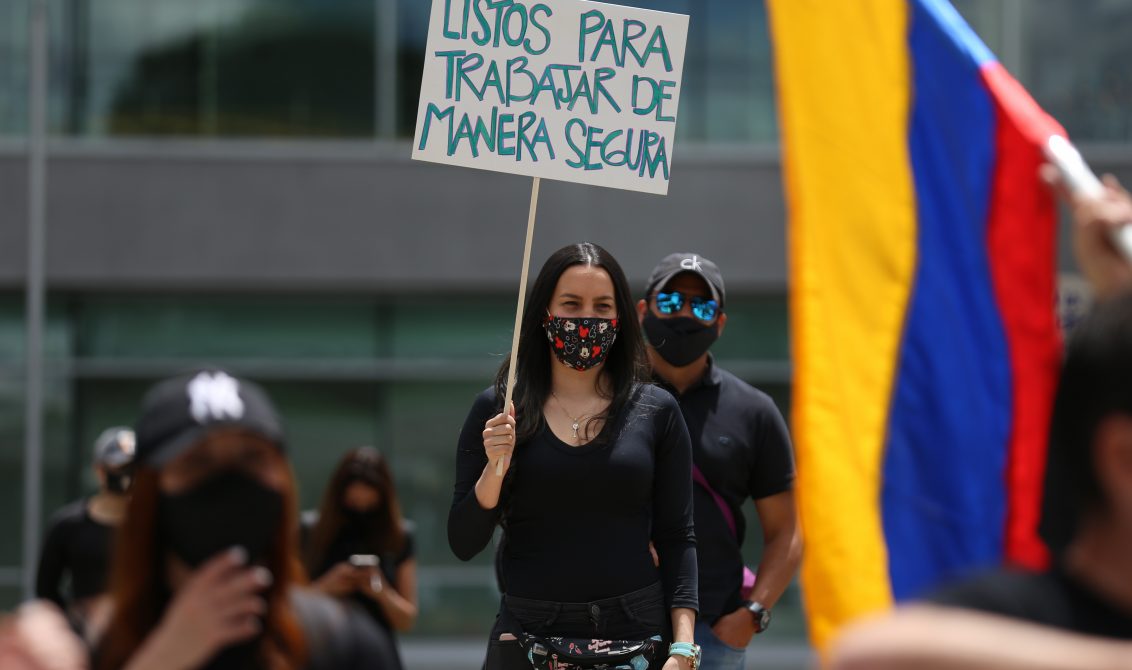 21 August 2020, Colombia, Bogota: A woman wearing a face mask holds a placard says "Ready to work safely" during a protest by aviation and tourism workers during the Coronavirus pandemic at El Dorado airport. Photo: Sergio Acero/colprensa/dpa