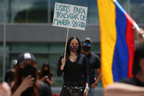 21 August 2020, Colombia, Bogota: A woman wearing a face mask holds a placard says "Ready to work safely" during a protest by aviation and tourism workers during the Coronavirus pandemic at El Dorado airport. Photo: Sergio Acero/colprensa/dpa