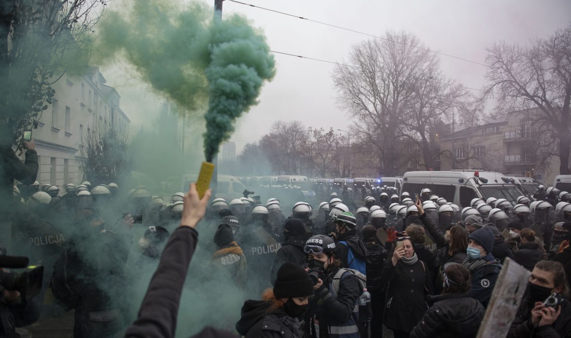 13 December 2020, Poland, Warsaw: A protester holds up a smoke bomb during an anti-government march against the ruling of Poland's top court that would impose a near total ban on abortion. Photo: Aleksander Kalka/ZUMA Wire/dpa