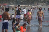 25 de Diciembre del 2020 Acapulco, Guerrero. Turistas utilizan cubre bocas y uno mas improvisa con una playera para cubrirse nariz y boca, mientras toman una caminata entre los cientos de bañistas que ayer visitaron la playa Revolcadero. Foto: Carlos Alberto Carbajal