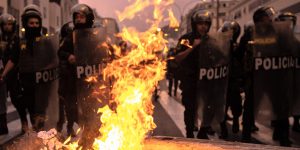 08 December 2022, Peru, Lima: Police officers stand behind burning barricades ignited by supporters of Peru's ousted President Castillo during a demonstration following Peru's Congress vote on Wednesday to remove Castillo from office and replace him with the vice president, shortly after Castillo tried to dissolve the legislature ahead of a planned vote on his ouster. Photo: Lucas Aguayo Araos/dpa